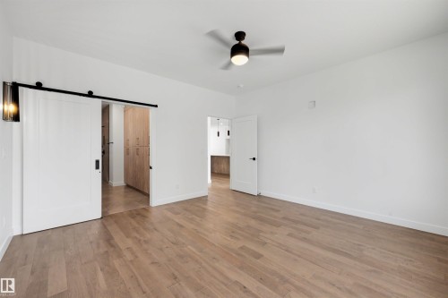 Spacious room with wood-finish flooring and a contemporary ceiling fan - 39 Elsinore Place, Edmonton, AB 
