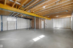 Unfinished basement with concrete flooring and exposed wood ceiling joists - 