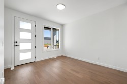 Entryway featuring a modern door with four frosted glass panels, matte black hardware, and wood-finish flooring - 