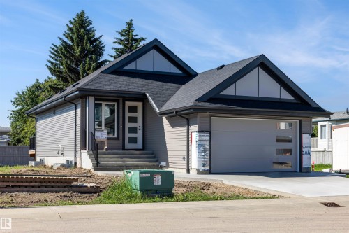 Contemporary home with gabled rooflines, dark asphalt shingles, and light gray horizontal siding - 39 Elsinore Place, Edmonton, AB 