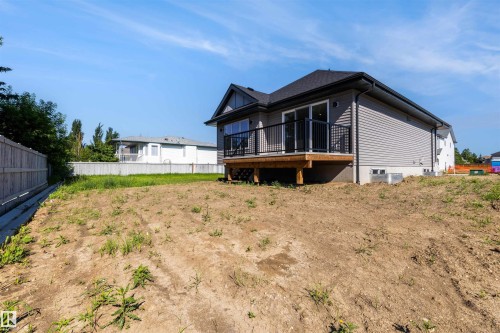 Newly constructed home featuring grey siding, a dark shingle roof, and a rear deck with black railings - 39 Elsinore Place, Edmonton, AB 
