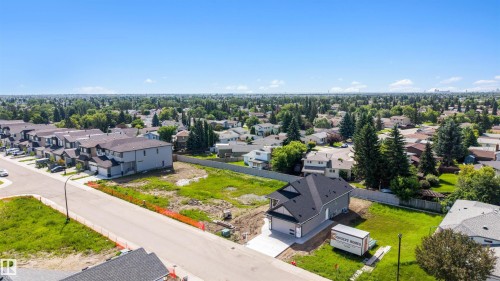 Newly constructed residence featuring a gray exterior, dark shingle roof, and an attached garage with a concrete driveway - 39 Elsinore Place, Edmonton, AB 