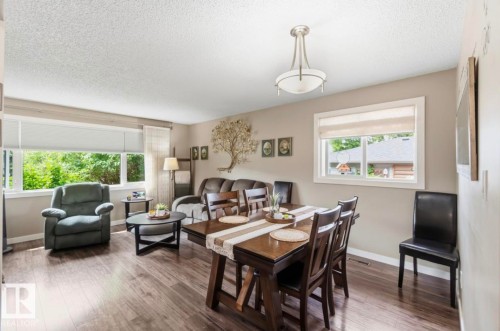 Open-concept living and dining area featuring wood-finish flooring, neutral wall tones, and recessed lighting - 4007 45 Street, Stony Plain, AB 