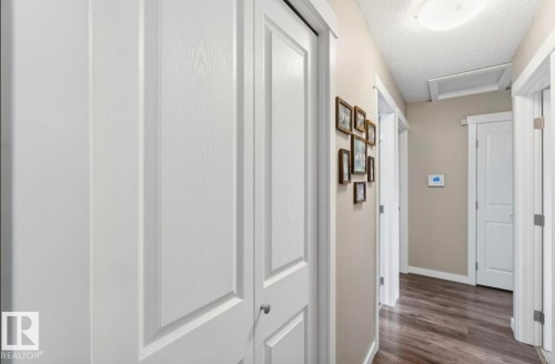 Hallway featuring wood-finish flooring, light neutral-toned walls, white trim, and recessed lighting - 4007 45 Street, Stony Plain, AB 