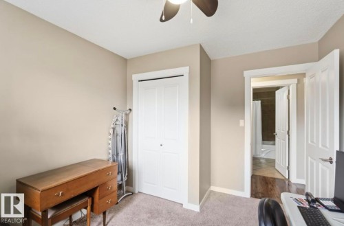 Room featuring light beige wall paint, white trim, and a ceiling fan with dark wood-finish blades - 4007 45 Street, Stony Plain, AB 