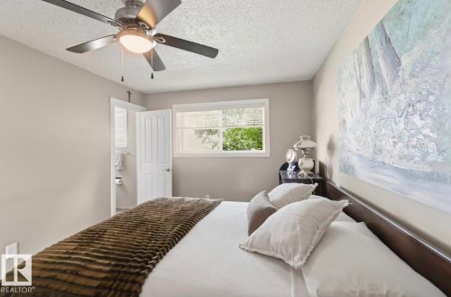 Room featuring a ceiling fan with integrated lighting, a window with horizontal blinds, and a white paneled door - 4007 45 Street, Stony Plain, AB 