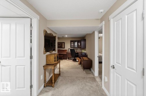 Hallway featuring neutral wall colors, carpeted flooring, and white paneled doors - 4007 45 Street, Stony Plain, AB 