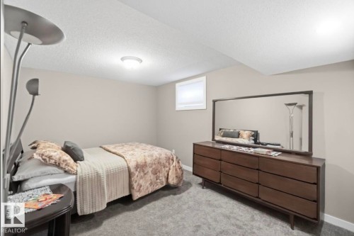 Carpeted room featuring neutral wall paint, a window with a white frame, and a flush-mount ceiling light - 4007 45 Street, Stony Plain, AB 
