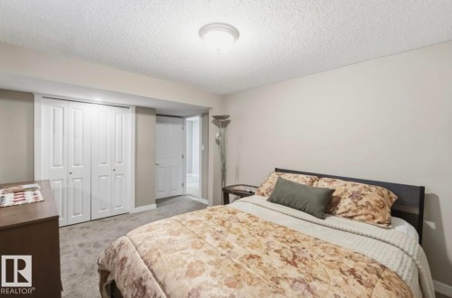 Bedroom featuring light gray wall paint, textured ceiling, and gray carpet flooring - 4007 45 Street, Stony Plain, AB 