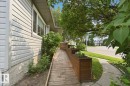 Accessible wood-finish ramp entrance featuring integrated planter boxes - 4007 45 Street, Stony Plain, AB 
