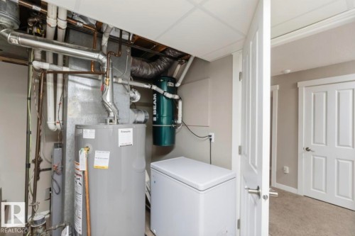 Utility area featuring a water heater, central vacuum system, and finished ceiling - 4007 45 Street, Stony Plain, AB 