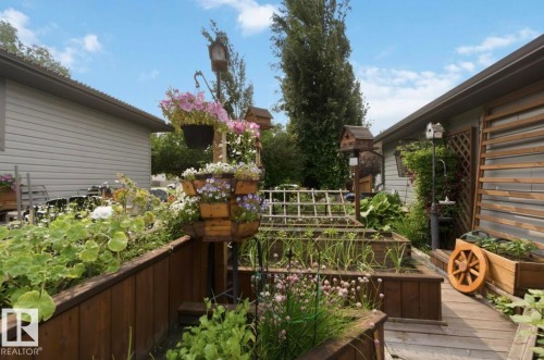 Raised garden beds featuring established plantings and decorative elements - 4007 45 Street, Stony Plain, AB 