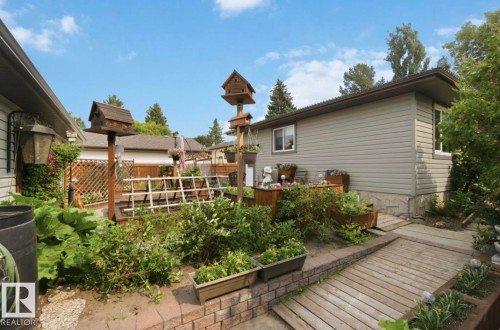 Expansive backyard featuring established landscaping and a multi-level wooden deck - 4007 45 Street, Stony Plain, AB 