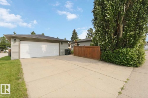 Detached garage with horizontal siding, a double white garage door, and two exterior light fixtures - 4007 45 Street, Stony Plain, AB 