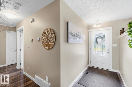 Entryway featuring a white door with decorative glass inserts and a semi-flush mount ceiling light - 4007 45 Street, Stony Plain, AB 