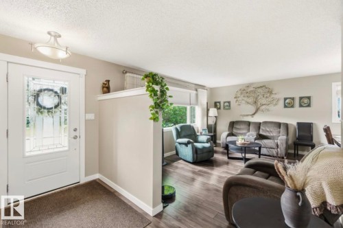 Entryway featuring a white door with decorative glass inserts, overhead flush mount lighting, and wood-finish flooring - 4007 45 Street, Stony Plain, AB 