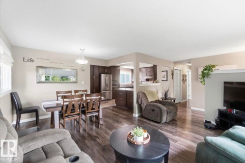 Open-concept living area with wood-finish flooring, recessed lighting, and neutral wall tones - 4007 45 Street, Stony Plain, AB 