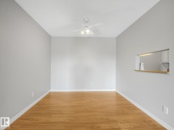 Spacious room with wood-finish flooring, light grey wall paint, and white trim - 