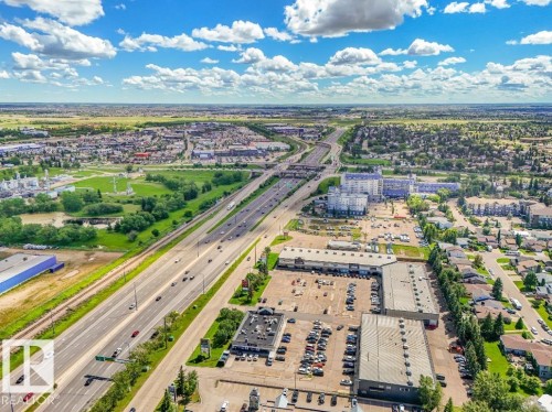 Aerial perspective showcasing a multi-lane highway, surrounding commercial structures, and residential areas - 301 10528 29 Avenue, Edmonton, AB 