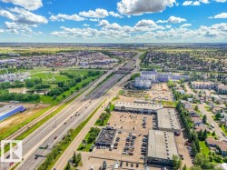 Aerial perspective showcasing a multi-lane highway, surrounding commercial structures, and residential areas - 