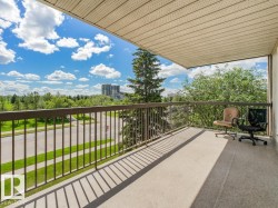 Spacious balcony featuring concrete flooring and a dark metal railing - 