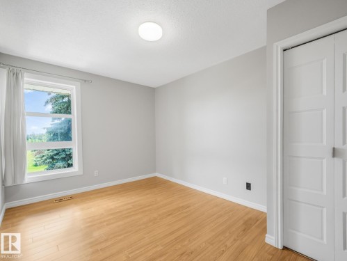 Bright room featuring wood-finish flooring, light grey walls, and white trim - 301 10528 29 Avenue, Edmonton, AB 