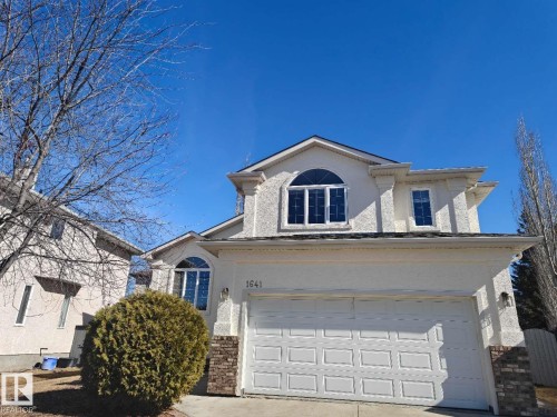Stucco exterior featuring an attached two-car garage with panel detailing - 1641 Forbes Way, Edmonton, AB - Outdoor