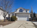 Two-story stucco residence featuring an attached double garage, an arched window, and a concrete driveway - 1641 Forbes Way, Edmonton, AB  - Outdoor 