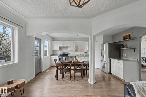Open-concept living area featuring wood-finish flooring throughout - 1619 Welbourn Cove, Edmonton, AB 