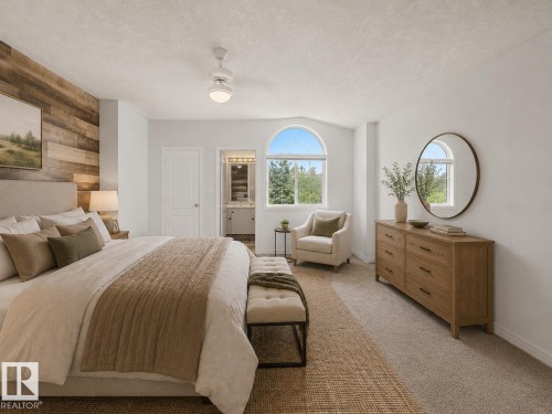 Spacious room featuring a wood-finish accent wall, arched window, ceiling fan with integrated lighting, and neutral carpeting - 1619 Welbourn Cove, Edmonton, AB 