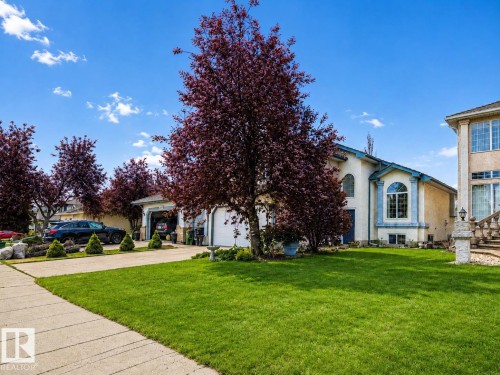 Stucco exterior with a prominent arched window and a secondary arched entry - 1619 Welbourn Cove, Edmonton, AB 