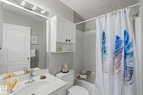 Full bathroom featuring a single vanity, integrated sink, and white cabinetry - 1619 Welbourn Cove, Edmonton, AB 
