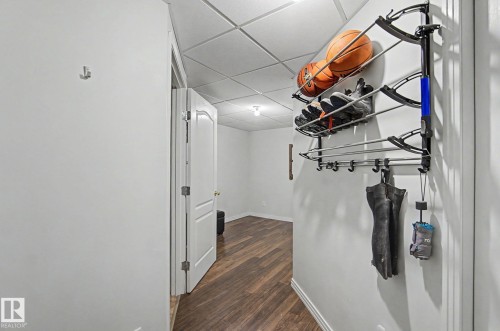 Hallway featuring wood-finish flooring, white walls, and a drop ceiling - 1619 Welbourn Cove, Edmonton, AB 
