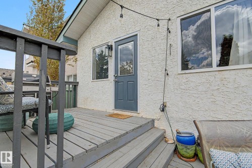 Exterior deck space featuring a grey wood-finish surface, staircase, and dark railings - 1619 Welbourn Cove, Edmonton, AB 