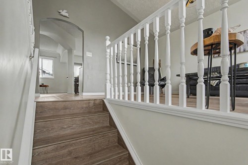 Wood-finish flooring on stairs and landing, featuring a white painted balustrade - 1619 Welbourn Cove, Edmonton, AB 