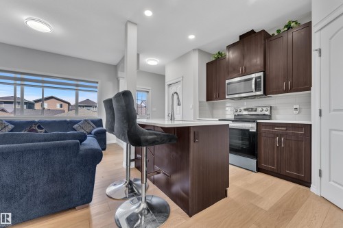 Open-concept kitchen and living area featuring wood-finish flooring - 2246 54 Street, Edmonton, AB 