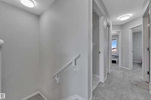 Upper level hallway featuring light gray walls, white trim, and gray carpeting - 2246 54 Street, Edmonton, AB 