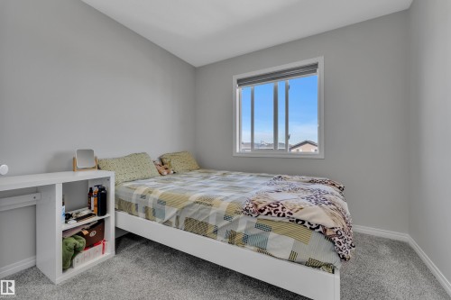 Bedroom featuring neutral gray walls, a window with horizontal blinds, and gray carpet flooring - 2246 54 Street, Edmonton, AB 