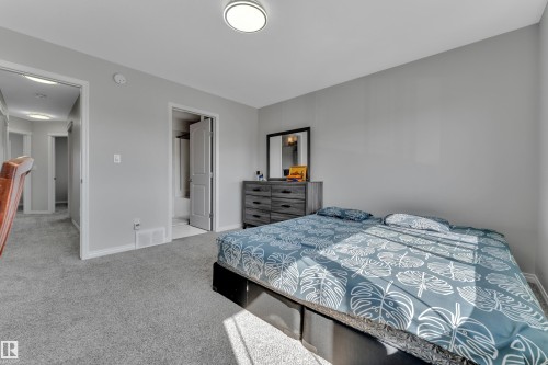 Carpeted bedroom featuring light gray walls, a flush-mount ceiling light, and white trim - 2246 54 Street, Edmonton, AB 