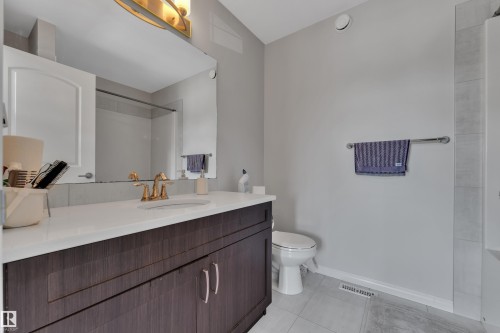 Bathroom featuring a vanity with a white countertop, dark wood-finish cabinetry, and gold-tone faucet - 2246 54 Street, Edmonton, AB 