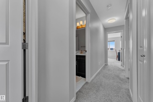 Hallway featuring light gray carpeting and white baseboards - 2246 54 Street, Edmonton, AB 
