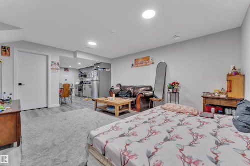 Open-concept living area featuring light gray walls, recessed ceiling lighting, and a combination of wood-finish flooring and carpeting - 2246 54 Street, Edmonton, AB 