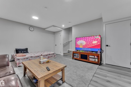 Lower level recreation space featuring light gray walls, recessed lighting, and wood-finish flooring - 2246 54 Street, Edmonton, AB 