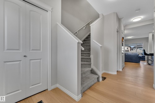 Carpeted staircase with white handrails and wood-finish flooring - 2246 54 Street, Edmonton, AB 