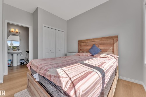Bedroom featuring wood-finish flooring, light gray wall paint, and white baseboards - 2246 54 Street, Edmonton, AB 