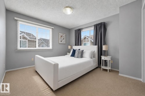 Light gray bedroom featuring two windows with horizontal blinds and dark gray drapery panels - 126 2051 Towne Centre Boulevard, Edmonton, AB 