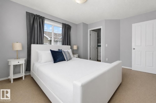 Carpeted bedroom featuring light gray walls, a window with dark drapery, and white trim - 126 2051 Towne Centre Boulevard, Edmonton, AB 
