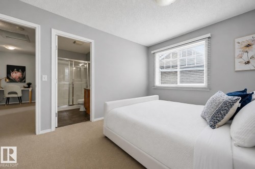 Bedroom featuring neutral wall colors, carpet flooring, a window with horizontal blinds, and direct access to a bathroom with a glass-enclosed shower - 126 2051 Towne Centre Boulevard, Edmonton, AB 