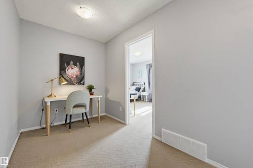 Carpeted hallway with light gray walls, white baseboards, and a flush-mount ceiling light - 126 2051 Towne Centre Boulevard, Edmonton, AB 