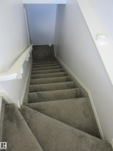 Carpeted staircase featuring a painted handrail and neutral wall finishes - 64 Heatherglen Close, Spruce Grove, AB 